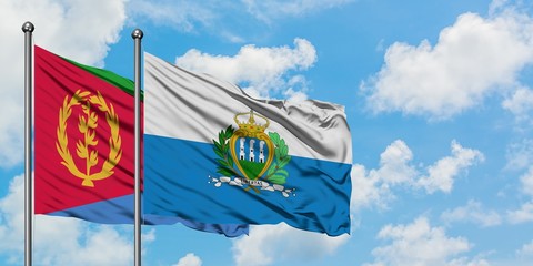 Eritrea and San Marino flag waving in the wind against white cloudy blue sky together. Diplomacy...