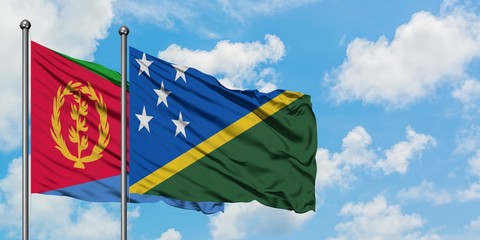 Eritrea and Solomon Islands flag waving in the wind against white cloudy blue sky together. Diplomacy concept, international relations.