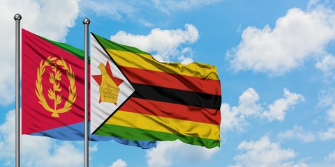 Eritrea and Zimbabwe flag waving in the wind against white cloudy blue sky together. Diplomacy concept, international relations.