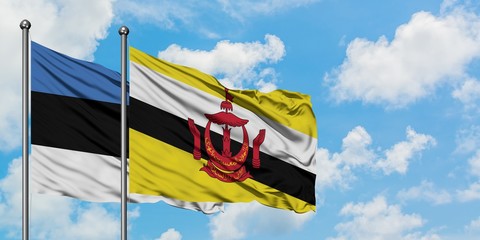 Estonia and Brunei flag waving in the wind against white cloudy blue sky together. Diplomacy...