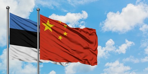 Estonia and China flag waving in the wind against white cloudy blue sky together. Diplomacy...