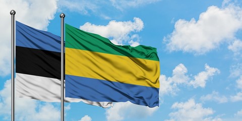 Estonia and Gabon flag waving in the wind against white cloudy blue sky together. Diplomacy concept, international relations.