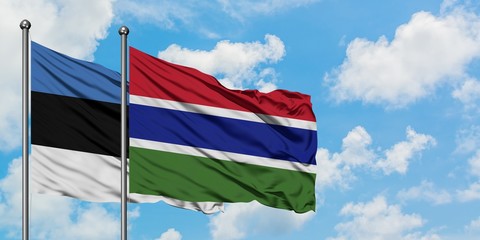 Estonia and Gambia flag waving in the wind against white cloudy blue sky together. Diplomacy concept, international relations.