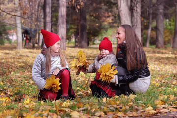 happy mother and daughters in autumn park