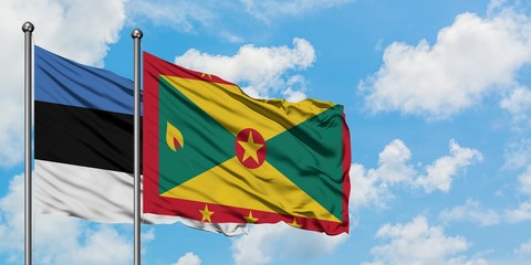 Estonia and Grenada flag waving in the wind against white cloudy blue sky together. Diplomacy concept, international relations.