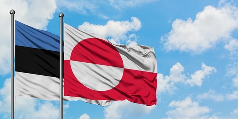 Estonia and Greenland flag waving in the wind against white cloudy blue sky together. Diplomacy concept, international relations.