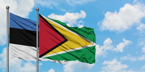 Estonia and Guyana flag waving in the wind against white cloudy blue sky together. Diplomacy concept, international relations.