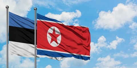 Estonia and North Korea flag waving in the wind against white cloudy blue sky together. Diplomacy concept, international relations.