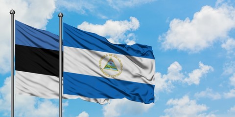 Estonia and Nicaragua flag waving in the wind against white cloudy blue sky together. Diplomacy concept, international relations.