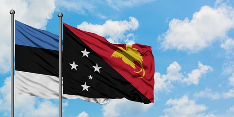 Estonia and Papua New Guinea flag waving in the wind against white cloudy blue sky together. Diplomacy concept, international relations.