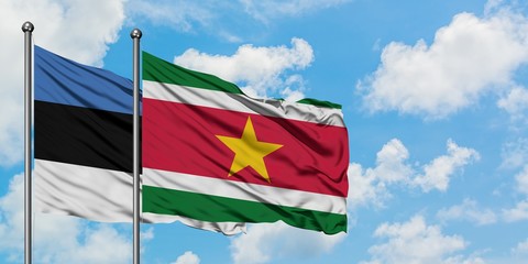 Estonia and Suriname flag waving in the wind against white cloudy blue sky together. Diplomacy concept, international relations.