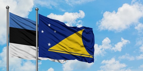 Estonia and Tokelau flag waving in the wind against white cloudy blue sky together. Diplomacy concept, international relations.