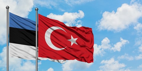 Estonia and Turkey flag waving in the wind against white cloudy blue sky together. Diplomacy concept, international relations.