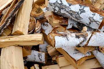 Preparation of firewood for the winter. firewood background, Stacks of firewood in the forest. Pile of firewood.