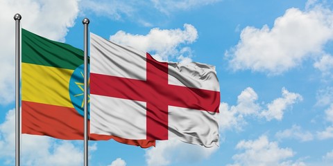 Ethiopia and England flag waving in the wind against white cloudy blue sky together. Diplomacy concept, international relations.