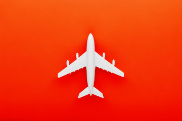 White passenger model airplane on a bright red background. Free space for text
