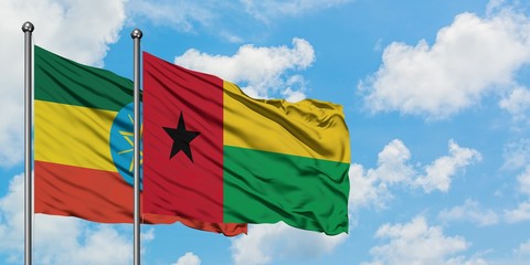 Ethiopia and Guinea Bissau flag waving in the wind against white cloudy blue sky together. Diplomacy concept, international relations.