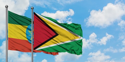 Ethiopia and Guyana flag waving in the wind against white cloudy blue sky together. Diplomacy concept, international relations.