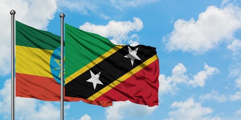 Ethiopia and Saint Kitts And Nevis flag waving in the wind against white cloudy blue sky together. Diplomacy concept, international relations.