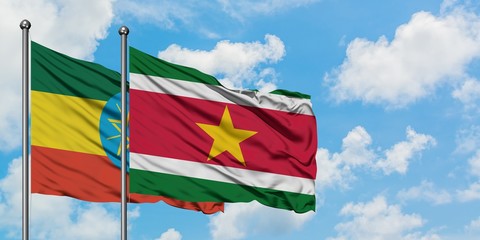 Ethiopia and Suriname flag waving in the wind against white cloudy blue sky together. Diplomacy concept, international relations.