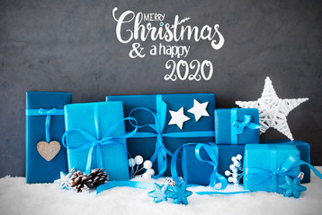 English Calligraphy Merry Christmas And A Happy 2020. Turquoise Gift With Bow And Christmas Decoration. Black Background With Snow