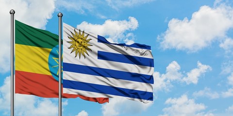 Ethiopia and Uruguay flag waving in the wind against white cloudy blue sky together. Diplomacy concept, international relations.
