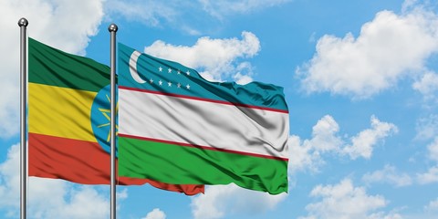 Ethiopia and Uzbekistan flag waving in the wind against white cloudy blue sky together. Diplomacy concept, international relations.
