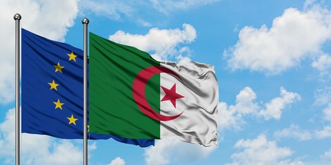 European Union and Algeria flag waving in the wind against white cloudy blue sky together....