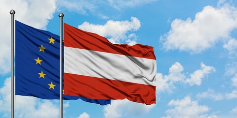 European Union and Austria flag waving in the wind against white cloudy blue sky together. Diplomacy concept, international relations.