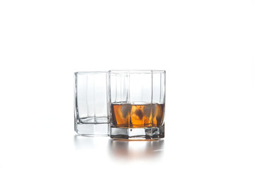 Two glasses of whiskey with ice cubes isolated on light background..