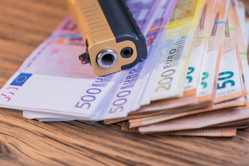 Black and gold gun pistol and money euros background