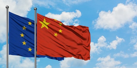 European Union and China flag waving in the wind against white cloudy blue sky together. Diplomacy concept, international relations.