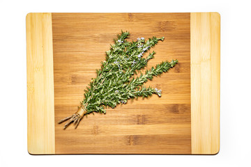 Bound bunch of Rosemary on a wooden cutting board isolated.