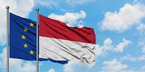 European Union and Indonesia flag waving in the wind against white cloudy blue sky together. Diplomacy concept, international relations.