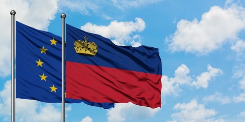 European Union and Liechtenstein flag waving in the wind against white cloudy blue sky together. Diplomacy concept, international relations.