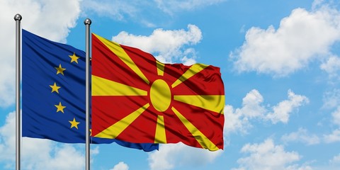 European Union and Macedonia flag waving in the wind against white cloudy blue sky together. Diplomacy concept, international relations.