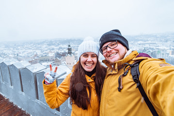 couple tourists taking selfie with beautiful city view in winter time on background