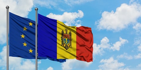 European Union and Moldova flag waving in the wind against white cloudy blue sky together. Diplomacy concept, international relations.