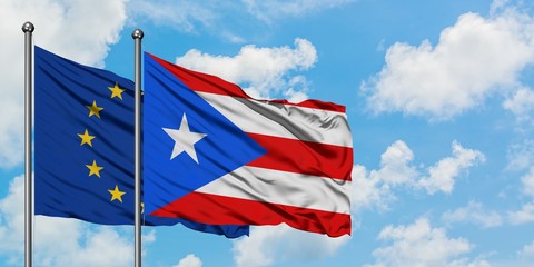 European Union and Puerto Rico flag waving in the wind against white cloudy blue sky together. Diplomacy concept, international relations.