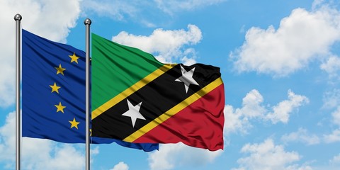 European Union and Saint Kitts And Nevis flag waving in the wind against white cloudy blue sky together. Diplomacy concept, international relations.