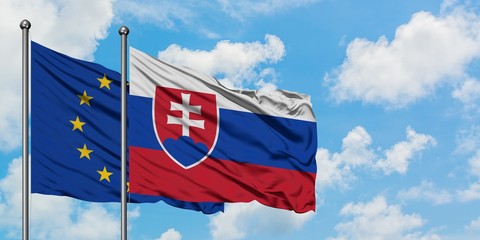 European Union and Slovakia flag waving in the wind against white cloudy blue sky together. Diplomacy concept, international relations.