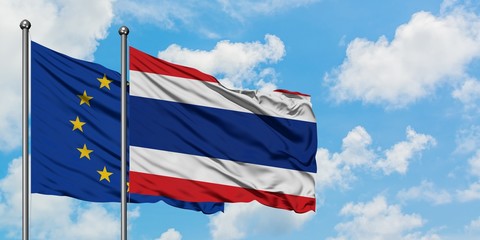 European Union and Thailand flag waving in the wind against white cloudy blue sky together. Diplomacy concept, international relations.