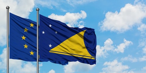 European Union and Tokelau flag waving in the wind against white cloudy blue sky together. Diplomacy concept, international relations.
