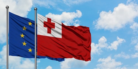 European Union and Tonga flag waving in the wind against white cloudy blue sky together. Diplomacy concept, international relations.