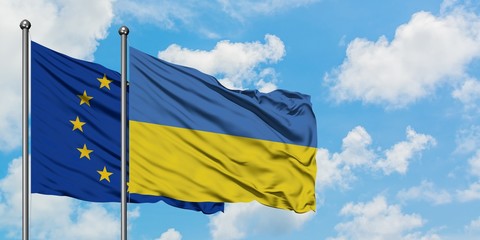European Union and Ukraine flag waving in the wind against white cloudy blue sky together. Diplomacy concept, international relations.