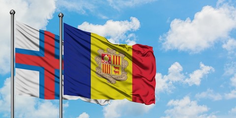 Faroe Islands and Andorra flag waving in the wind against white cloudy blue sky together. Diplomacy concept, international relations.