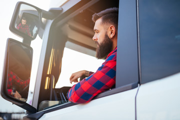 Young handsome bearded man driving his truck.