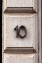 black metal number ten on stone wall