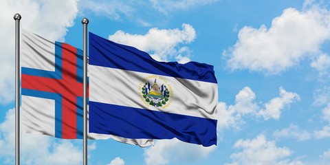 Faroe Islands and El Salvador flag waving in the wind against white cloudy blue sky together. Diplomacy concept, international relations.