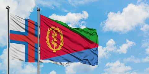 Faroe Islands and Eritrea flag waving in the wind against white cloudy blue sky together. Diplomacy concept, international relations.